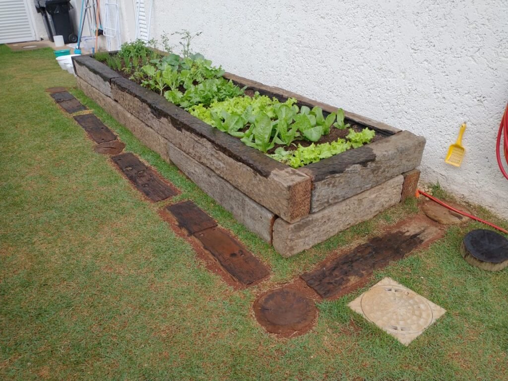 Horta com dormentes de madeira de demolição em jardim.